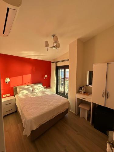 a bedroom with a bed with a red wall at Villa Seferis in Seferihisar