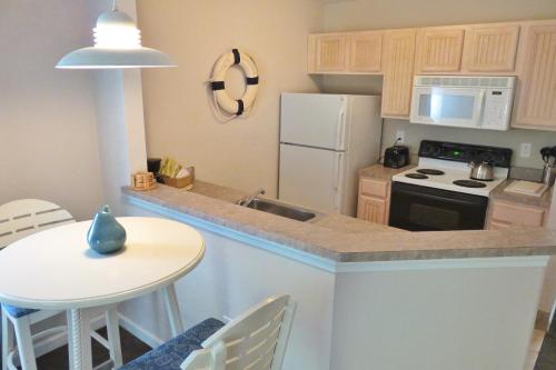 a kitchen with a white refrigerator and a table at The Villages at Ocean Edge Resort & Golf Club in Brewster