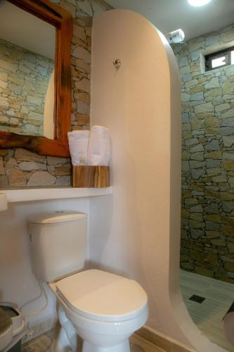 a bathroom with a toilet and a stone wall at Loft para grupos parqueadero gratis LIRIO in Jardin