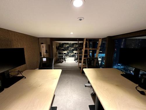 an office with wooden tables and chairs and a room at Nomad Live Hostel in Busan