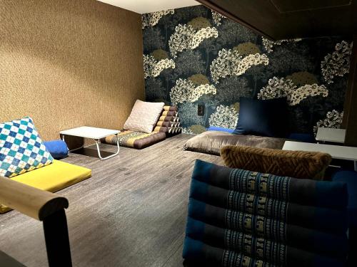 a living room with a couch and chairs in it at Nomad Live Hostel in Busan