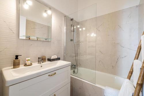 une salle de bain blanche avec un lavabo et une douche dans l'établissement 13 ANDRE1 - Cozy studio 100m from the Croisette and the beaches, à Cannes