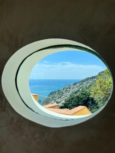 ein kreisförmiges Fenster mit Bergblick in der Unterkunft Tenuta La Picola in Furore