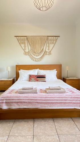 a bedroom with a large bed with two pillows at Casa Lua Guesthouse in Burgau