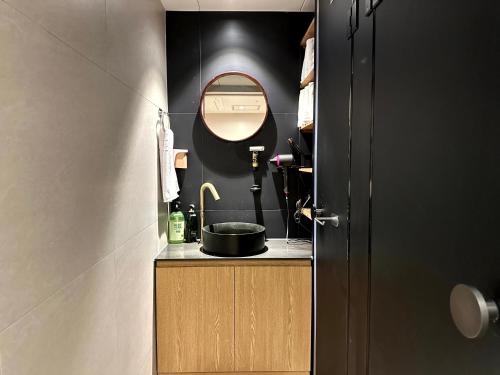 a small bathroom with a sink and a mirror at Nomad Live Hostel in Busan