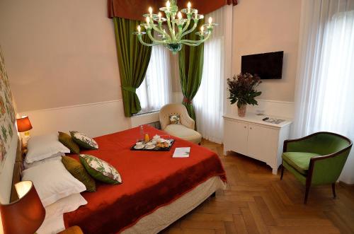 une chambre d'hôtel avec un lit et un lustre dans l'établissement B&B Villa Ines, sur le Lido de Venise