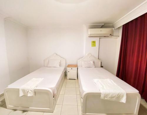 two beds in a room with a red curtain at Falcon heaven in 6th Of October
