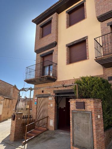a brick building with a door and two balconies at Casa La Parra en Teruel in Villastar