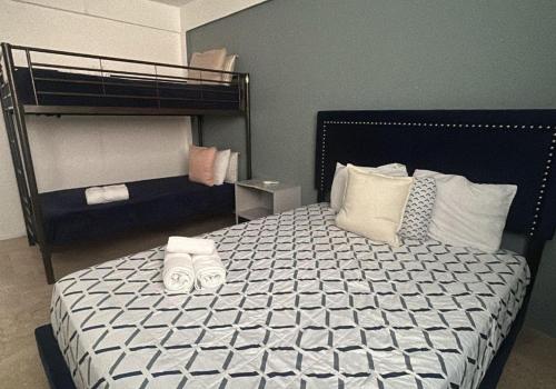 a bedroom with a bed with two bunk beds at The Pelican Poshtel in San Juan