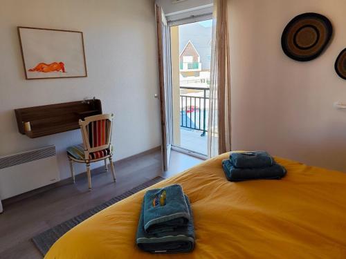 a bedroom with a bed with two towels on it at Vue baie à l'infini in Le Crotoy