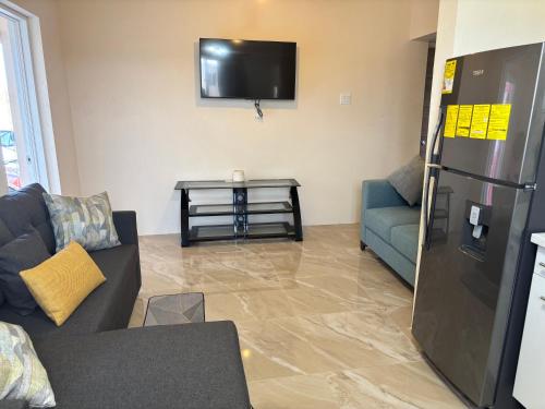 a living room with a couch and a tv at Serenity Haven in Saint Philip