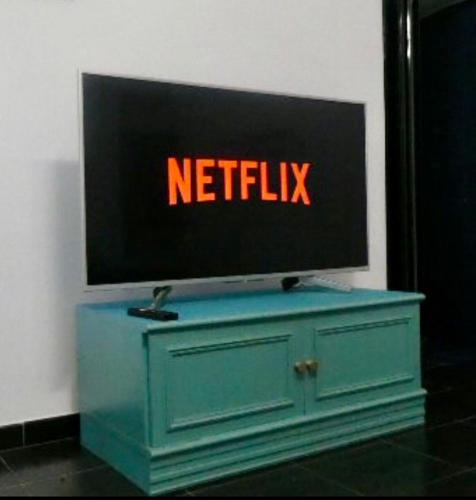 a tv on a wall with a netflix sign on it at La Casita, appartamento vicino alla Sacra di San Michele, ideale per coppie, con cucina e ingresso indipendente in Caprie