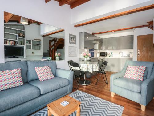a living room with a couch and chairs and a kitchen at Seafarer's Haven in Porthmadog
