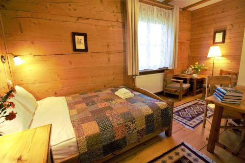 a bedroom with a bed in a wooden room at Zagroda Kuwasy in Woźnawieś