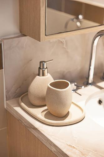 two cups sitting on a counter next to a sink at The Boulevard Suite Luxury near Burj Khalifa in Dubai