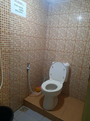 a bathroom with a toilet in a tiled wall at Mawar Villa with Private Pool in Situ 2