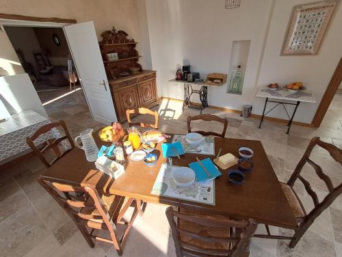 une salle à manger avec une table et des chaises en bois dans l'établissement Aux roses de Cèdres chambre Savane, à Salvagnac