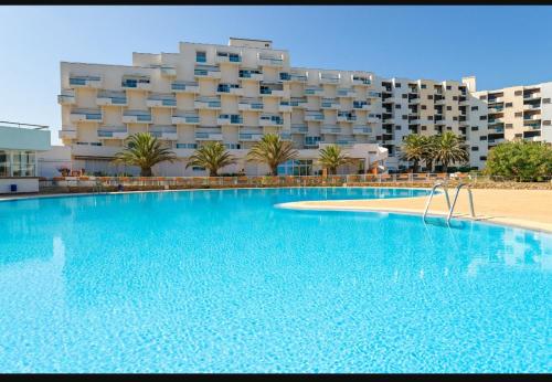 une grande piscine devant un hôtel dans l'établissement Grand studio, PISCINE, Vue magnifique plage, 4 personnes, secteur Allée des Arts Le Lydia, au Barcarès