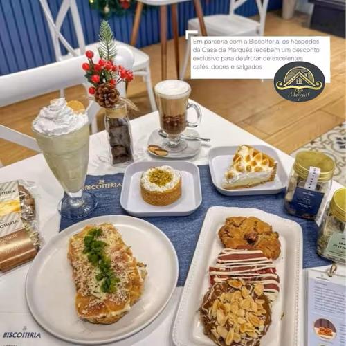 a table with plates of food and drinks on it at Casa da Marquês in Petrópolis