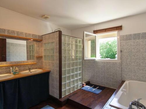 a bathroom with two sinks and a tub and a window at Villa Cethi in Boissières