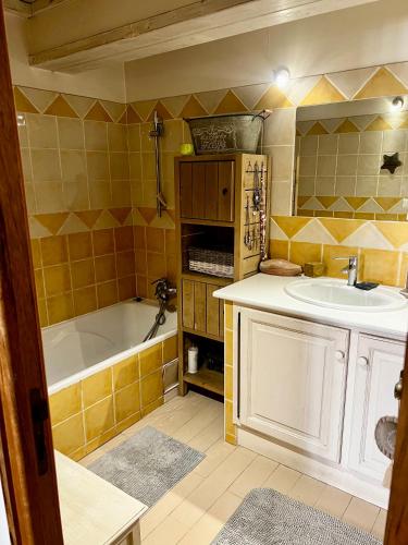 une salle de bain avec un lavabo et une baignoire dans l'établissement Jolie maison chaleureuse, à Sainte-Tulle