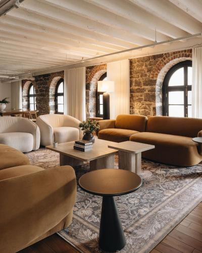 a lobby with couches and tables and a brick wall at Saint Sulpice Lofts by Bakan - Old Montreal in Montréal