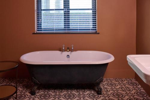 a bath tub in a bathroom with a window at Hotel du Vin Bristol in Bristol