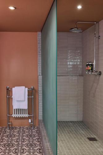 a bathroom with a shower with a towel on a chair at Hotel du Vin Bristol in Bristol