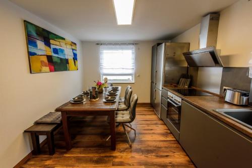 a small kitchen with a table and a kitchen gmaxwell gmaxwell gmaxwell gmaxwell gmaxwell at Charming Loft Ferienwohnung Bodensee in Meckenbeuren