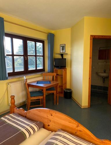 a hotel room with a bed and a table and a kitchen at Charlottenhaus in Kühndorf