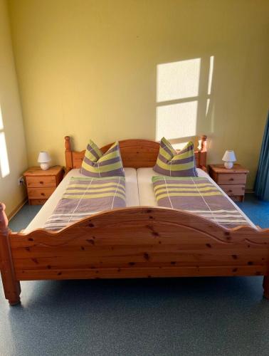 a bedroom with a wooden bed with two pillows at Charlottenhaus in Kühndorf