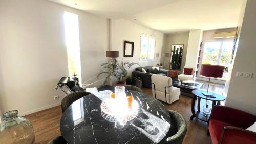 un salon avec une table et un canapé dans l'établissement Cosy penthouse Le Port 2 BR - 2 Bath, à Nice