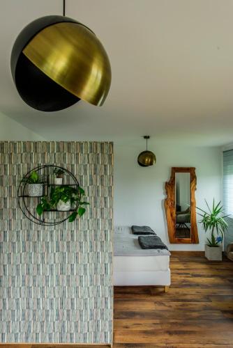 a bedroom with a bed and a gold light fixture at Charming Loft Ferienwohnung Bodensee in Meckenbeuren