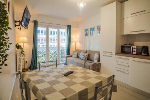 une cuisine et un salon avec une table et un canapé dans l'établissement Californie 8Pers Parking AC Wifi, à Nice