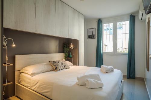 une chambre avec un grand lit avec deux serviettes dessus dans l'établissement Californie 8Pers Parking AC Wifi, à Nice