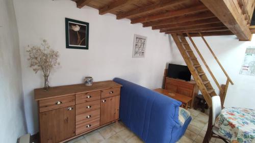a living room with a blue couch and a ladder at Gîtes Les Sorbes in champis