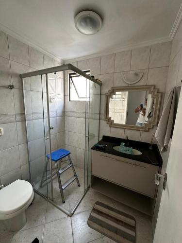 a bathroom with a sink and a toilet and a mirror at APT ALUGUEL Praia central in Balneário Camboriú