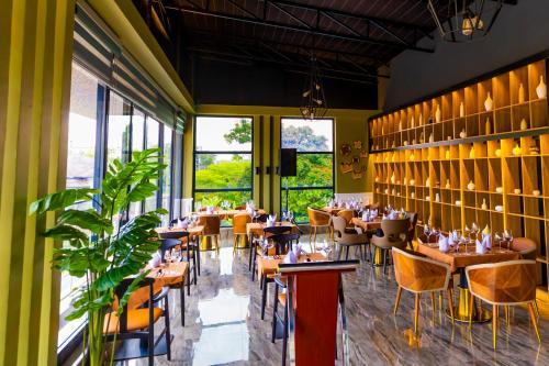 a restaurant with tables and chairs and large windows at T-Stone Apartments Kigali-Kimihurura in Kigali