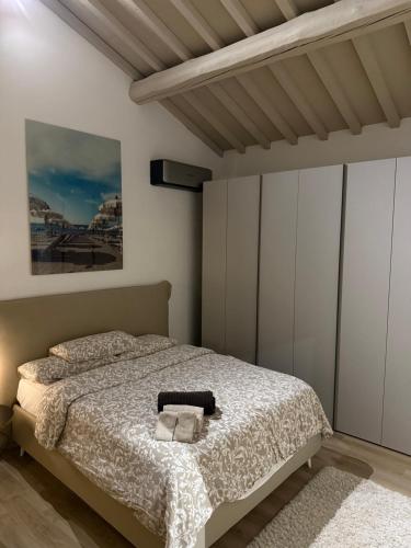 a bedroom with a bed and a painting on the wall at Casa Leoni Chianni - tuscan luxurious Villa in Chianni