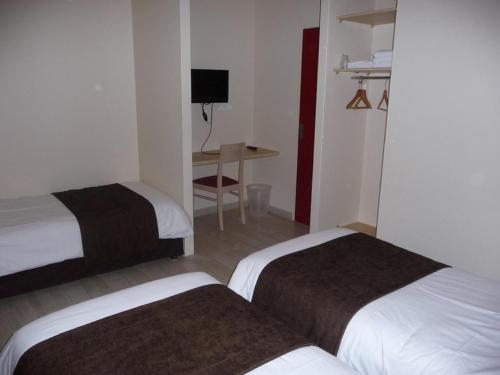 a hotel room with two beds and a desk at La Godinière in Cholet