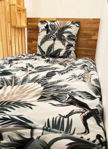 - un lit avec une couette en noir et blanc dans l'établissement Maisonnette au portes du Pyla, à La Teste-de-Buch