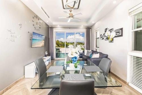 a living room with a glass table and a couch at Romantic Escape, Walk to Beach, Pool, Hammock in Long Bay Hills