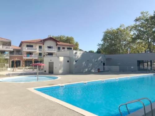 une grande piscine devant un immeuble dans l'établissement Maisonnette au portes du Pyla, à La Teste-de-Buch