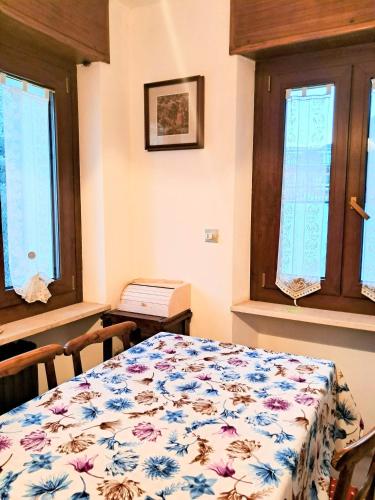 a bedroom with a bed and two windows at Alloggio Grande Joséphine in Oulx