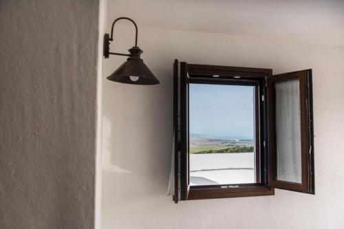 a mirror on a wall next to a light fixture at La Veleta de Vejer in Vejer de la Frontera