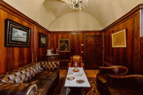 a living room with a leather couch and a table at Castello di Casalborgone, Luxury Italian Castle Hotel in Casalborgone