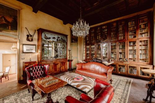 a living room with leather furniture and a chandelier at Castello di Casalborgone, Luxury Italian Castle Hotel in Casalborgone