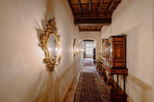 a hallway with a gold mirror on the wall at Castello di Casalborgone, Luxury Italian Castle Hotel in Casalborgone