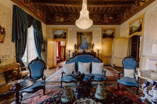 a living room with a couch and chairs and a chandelier at Castello di Casalborgone, Luxury Italian Castle Hotel in Casalborgone