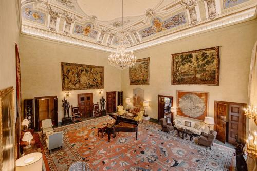 a large living room with a chandelier and a living room with a couch at Castello di Casalborgone, Luxury Italian Castle Hotel in Casalborgone